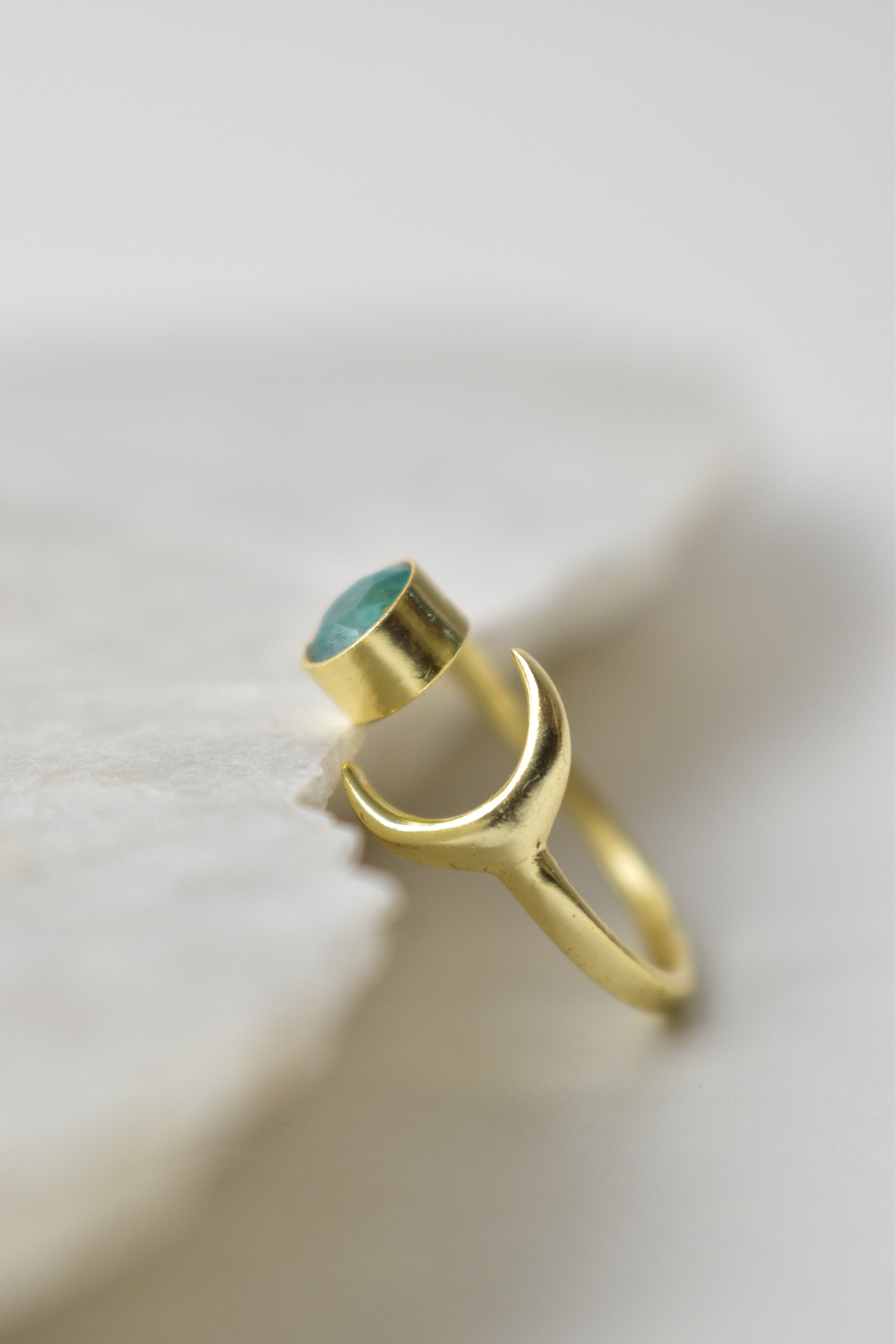 Gold ring with a emerald stone on a white background