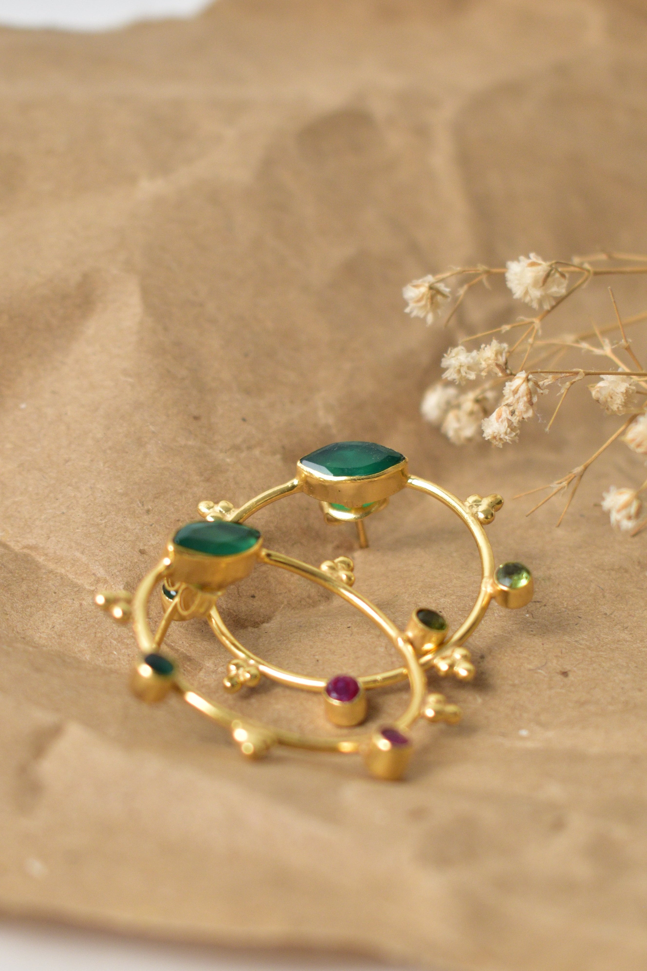 Gold ring with gemstones on a textured surface