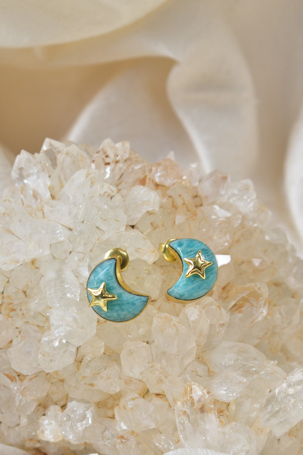 Earring with moon and star design on a crystal and flower background