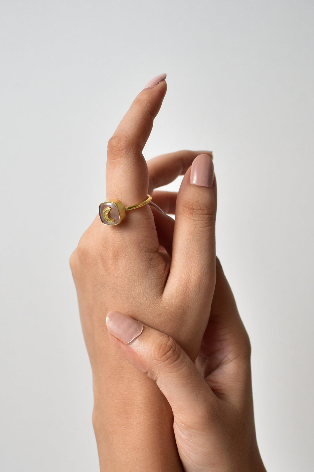 Two hands holding each other against a plain background