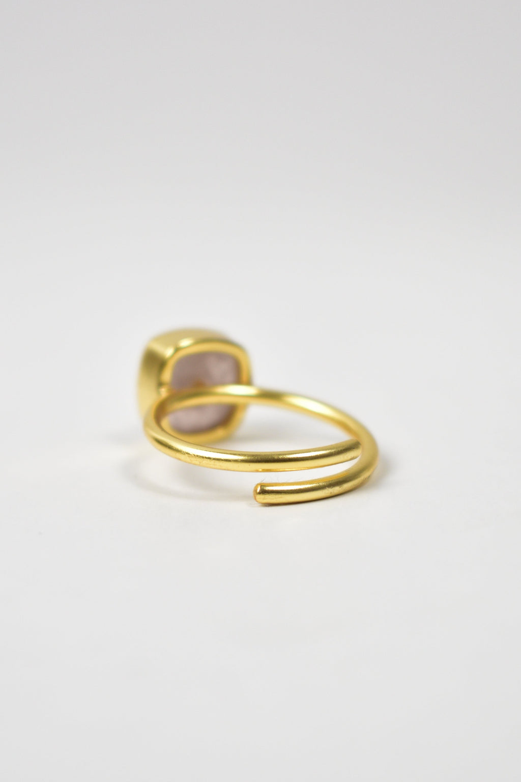 Gold hoop earring on a light gray background