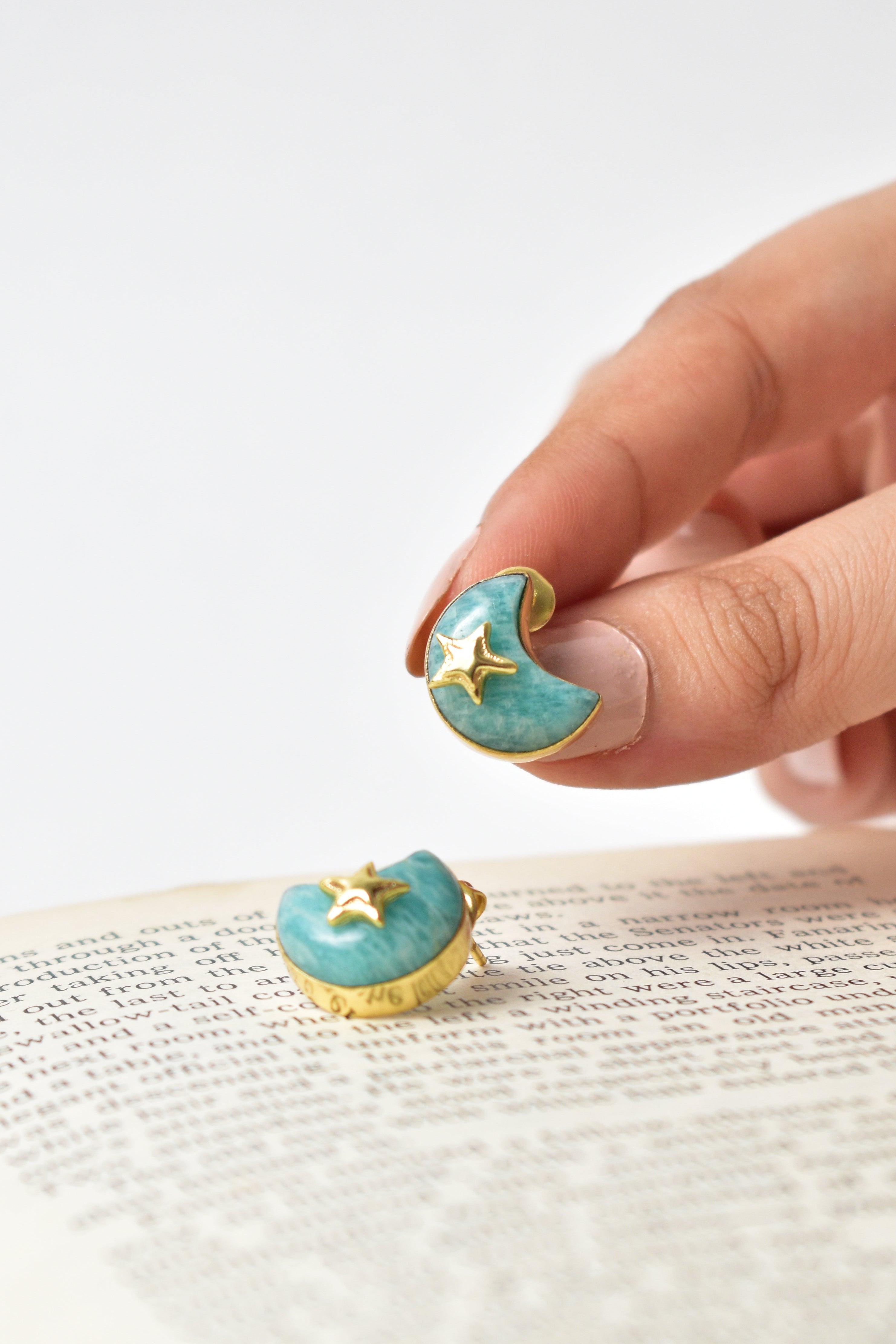 Turquoise earrings with star designs on a white background