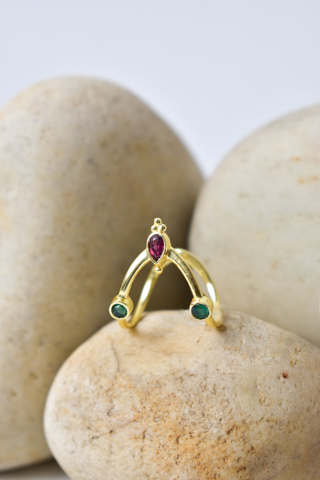 Gold ring with gemstones on a stone surface